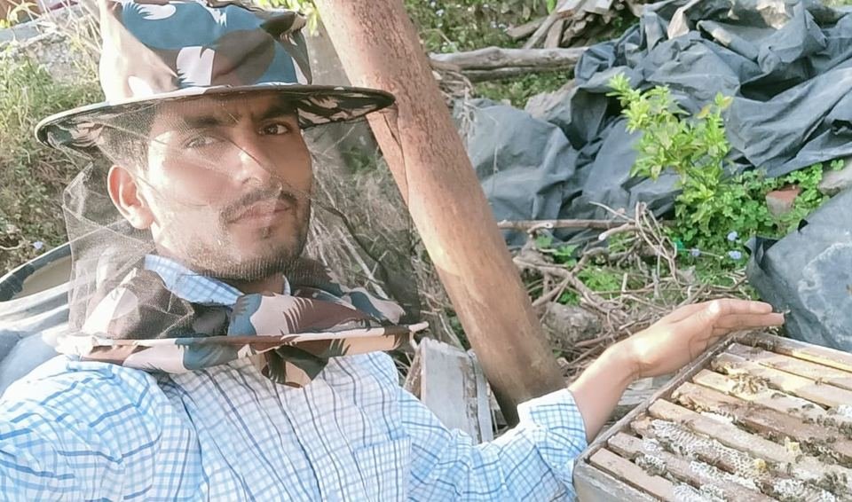 Beekeeper Kishore Upadhyay beside an open hive